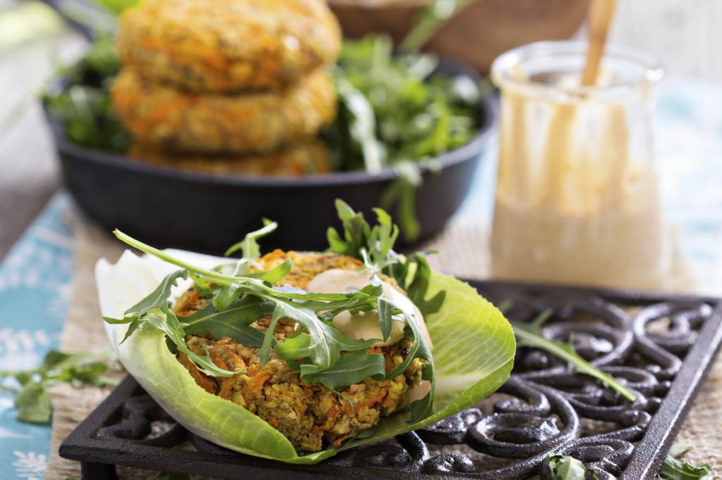 Vegan burgers with sweet potato served with arugula and peanut sauce